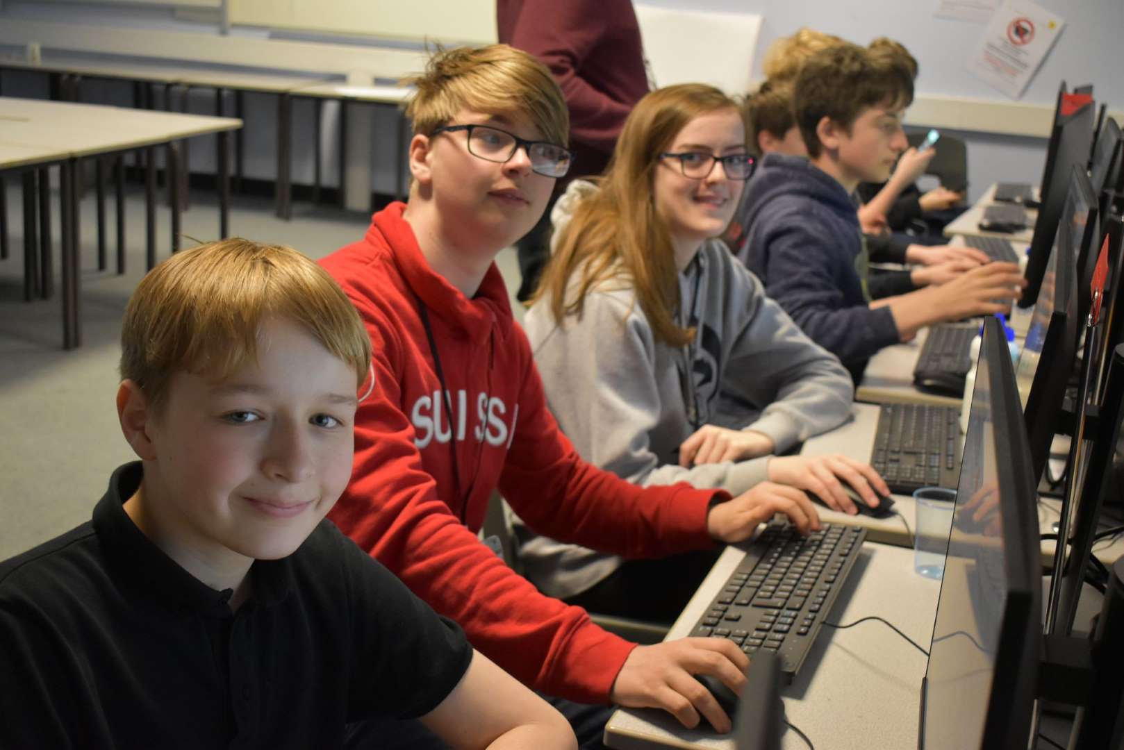 Boys and girls in front of computers learning Game Design